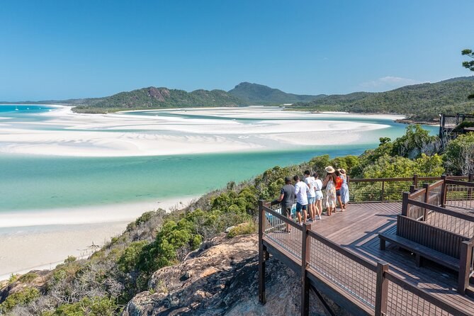 The timber lookout deck on the headland above Hill Inlet, walkers at the rail and the inlet's white sand running away to the south